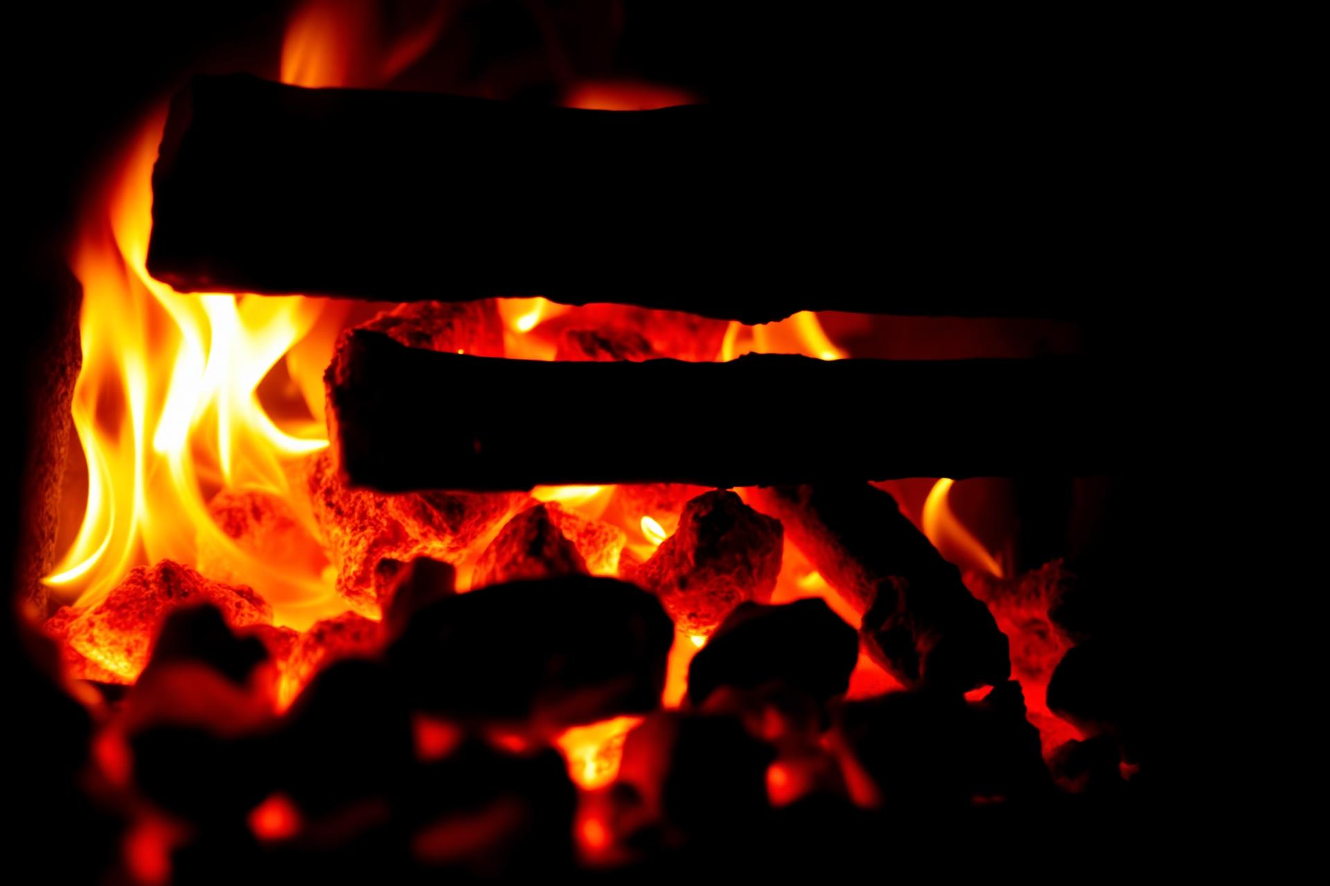 Glowing oak and maple embers at the base of the wood-fired oven.
